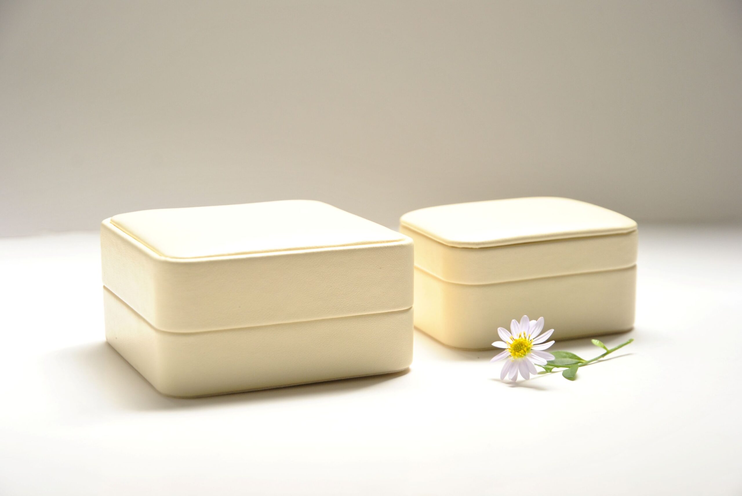 ベージュの革製ケース2個と白い花を添えた写真、上品な梱包例