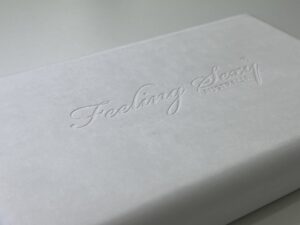 パルプモールド（ウェットプレス）製品にロゴをエンボス加工した表面のクローズアップ写真